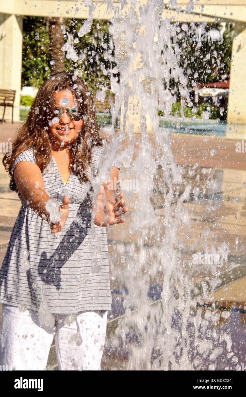 Bambina gioca nella fontana di acqua Foto Stock