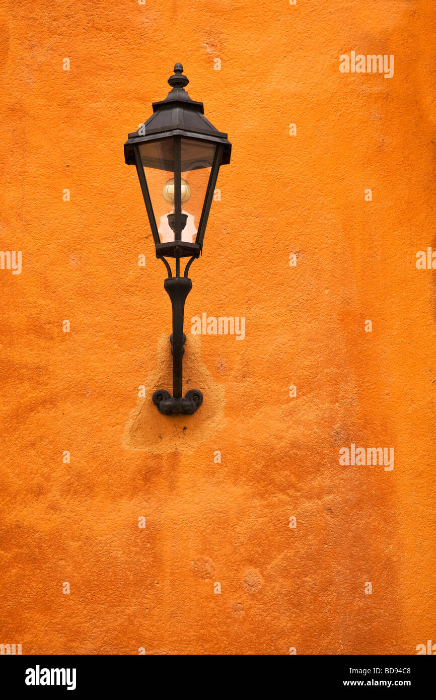 Tradizionale montato a parete in stile vecchia città strada lampada su una parete in terracotta Foto Stock