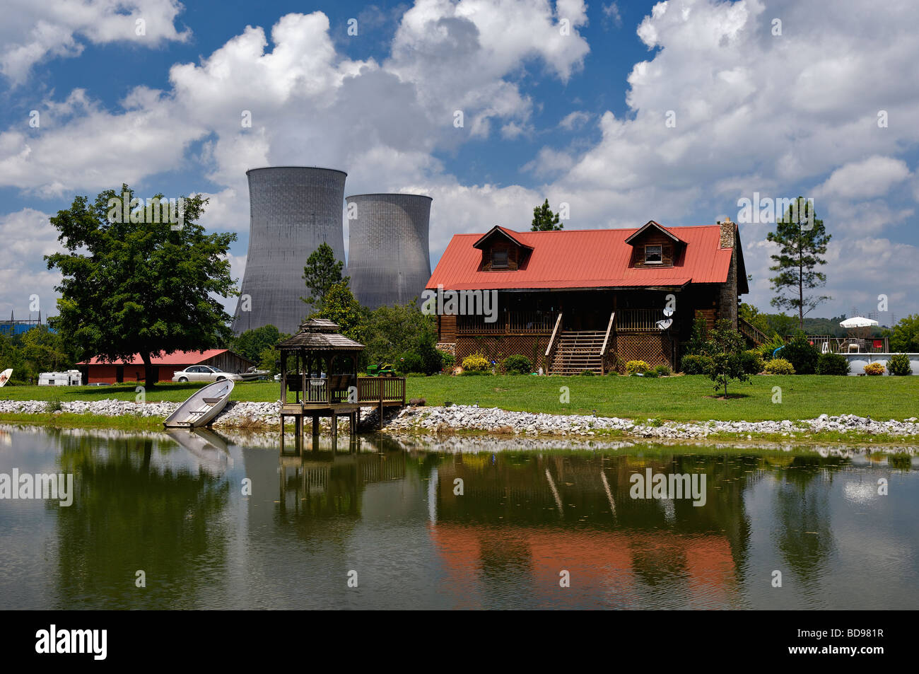 Cabin riflessa nel lago con Watt Bar Centrale Nucleare torri di raffreddamento dietro in Meigs e Rhea County Tennessee Foto Stock