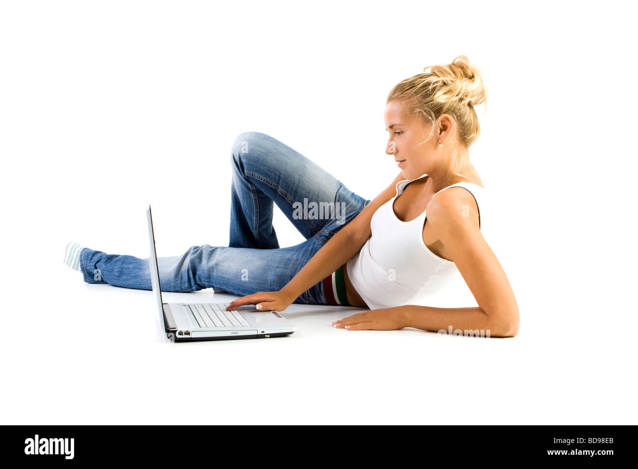 Ragazza bionda lavora con il computer portatile su sfondo bianco Foto Stock