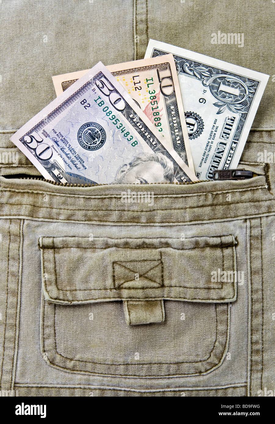 Tre differenti valute US dollar note nella tasca di un paio di pantaloni khaki Foto Stock