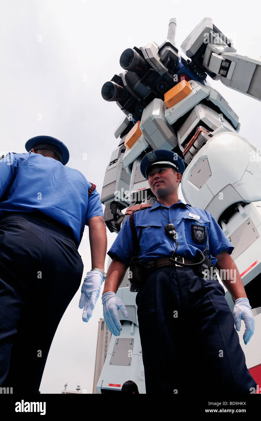 Poliziotti di stare accanto alla replica di gigante di fantascienza animazione robot Gundam in Seaside Park in Odaiba grande isola artificiale nella Baia di Tokyo, Giappone Foto Stock