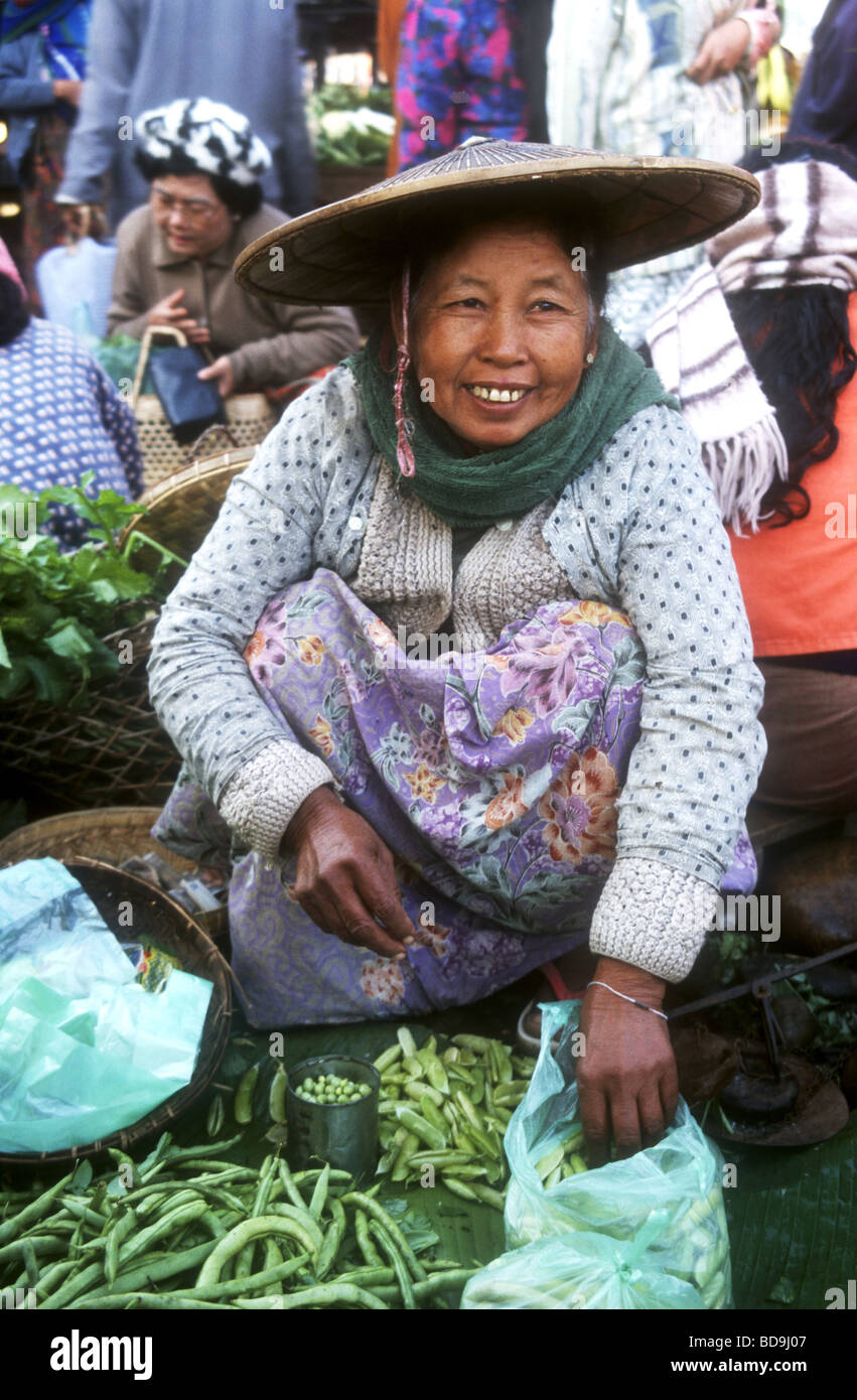 Donna birmano ,indossando il tradizionale cappello di paglia ,vendere verdure locali nel mercato a Myitkyina nel Nord del Myanmar Foto Stock