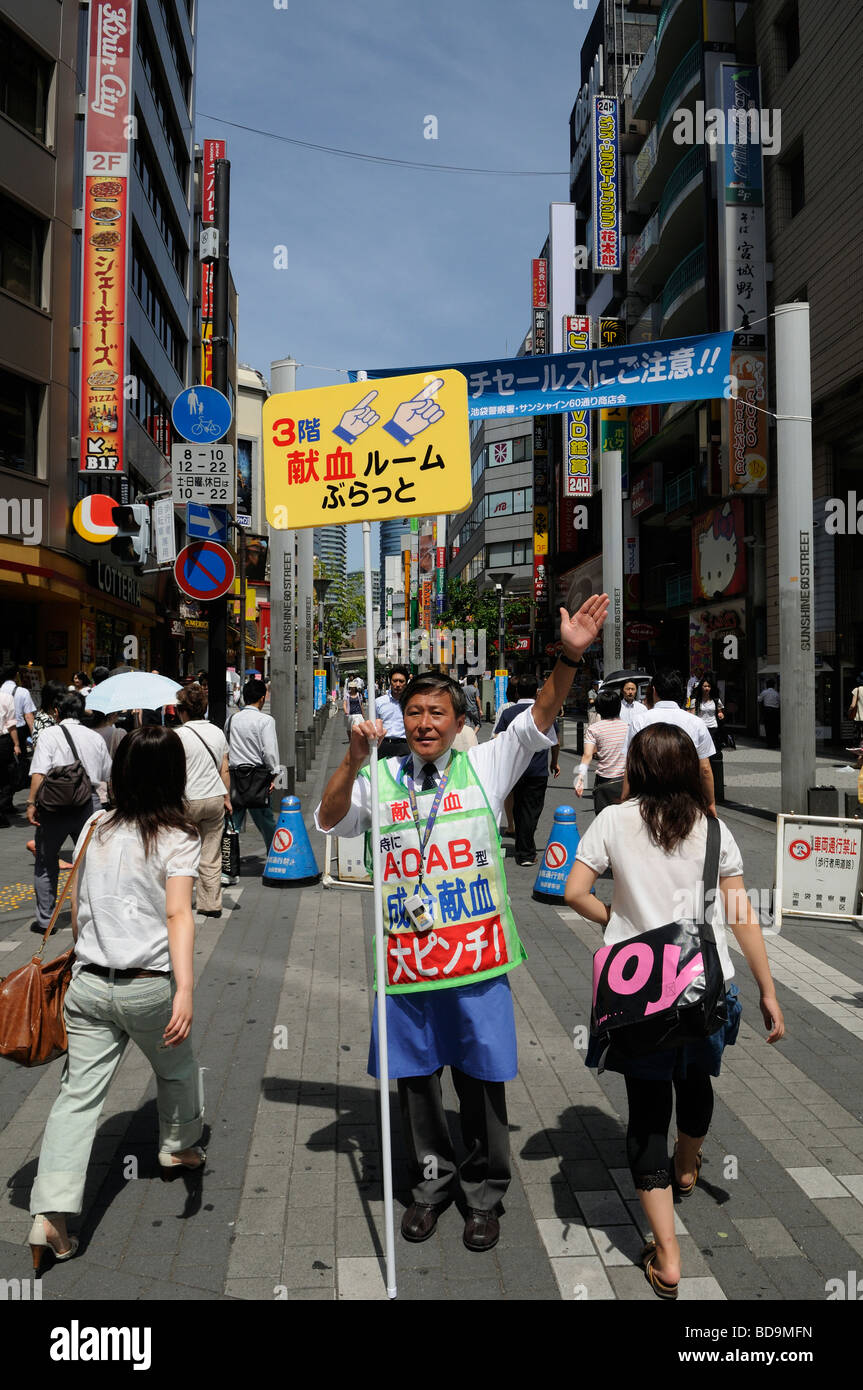 Un venditore dirige e annunciare le vendite al Sunshine Dori Street nel quartiere di Ikebukuro Tokyo Giappone Foto Stock