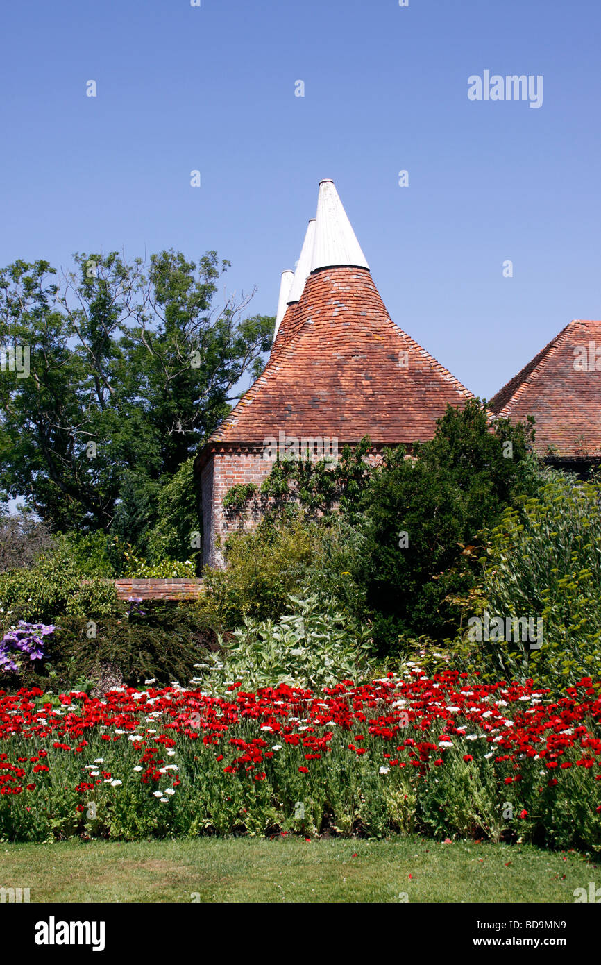 UN COLORATO GIARDINO DI CAMPAGNA DELLA CASA DI OAST INGLESE IN ESTATE. Foto Stock