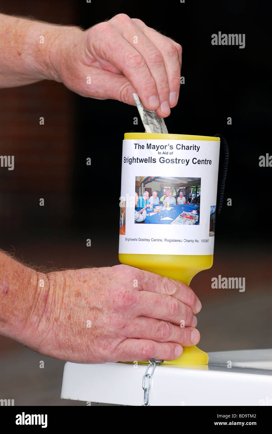 L'uomo la donazione di £ 5 al sindaco di Farnham's appello per un nuovo bagno per un gli anziani del centro, Lion & Lamb's Yard, Farnham, Surrey. Foto Stock