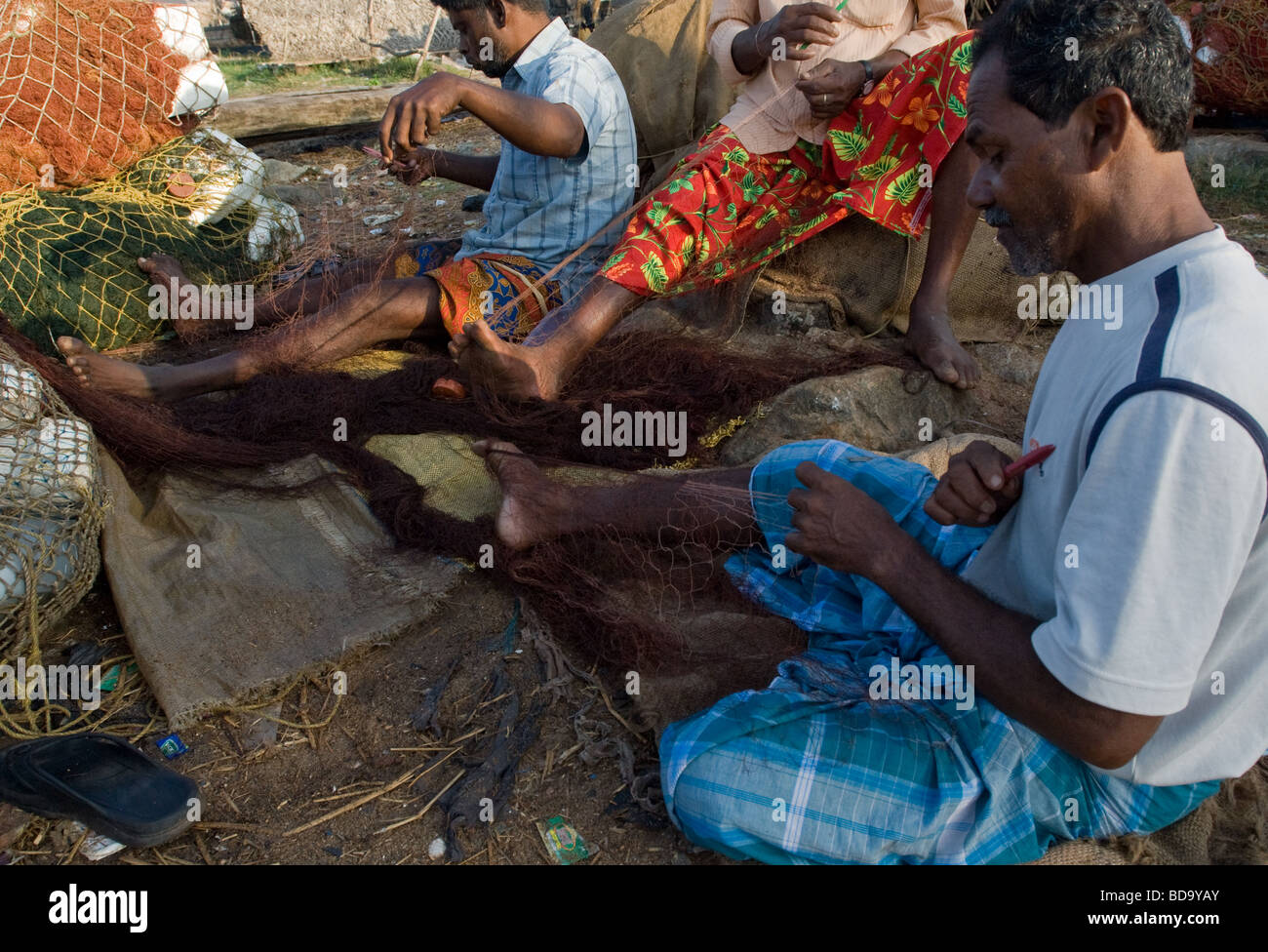 I pescatori la riparazione di loro reti in Kerala, nell India meridionale Foto Stock