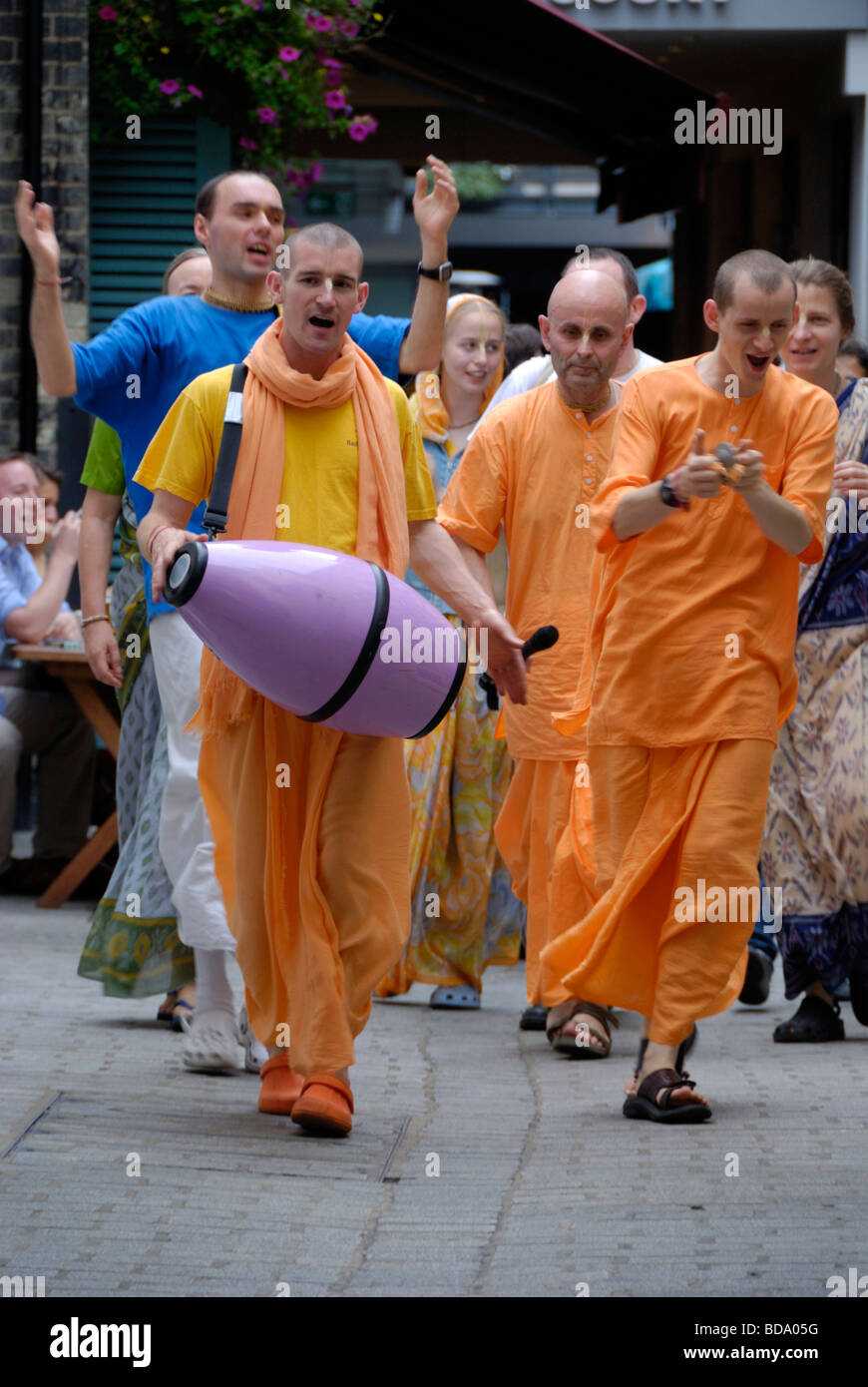 I membri dell'Hare Krishna circolazione cantando su una strada di Londra Foto Stock
