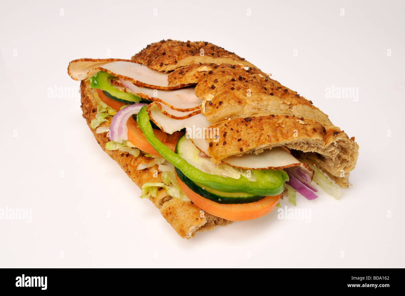 Alla metropolitana la Turchia sub o sandwich con lattuga, pomodoro, peperoni verdi, cetrioli e cipolle rosse su sfondo bianco, tagliato fuori. Foto Stock