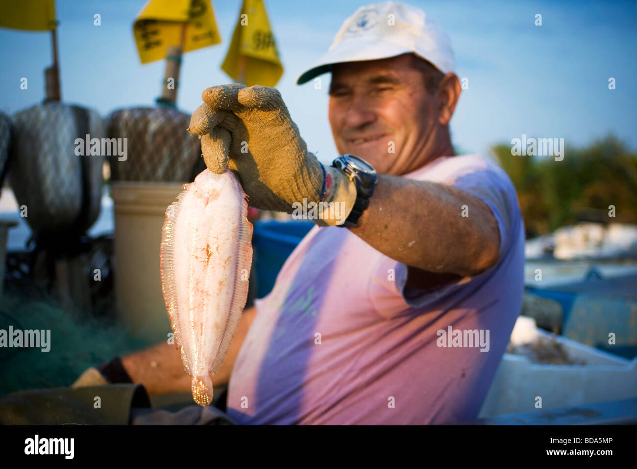 Un pescatore con una suola in mano Foto Stock