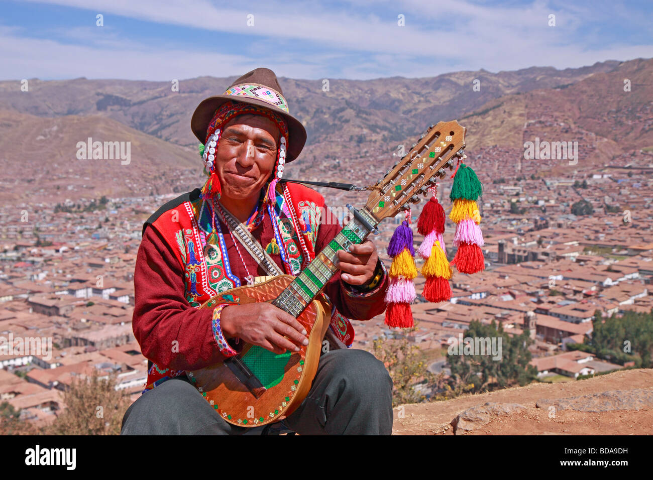 Uomo nativo di suonare la chitarra in corrispondenza di un punto di vista, Cuzco, Perù, Sud America Foto Stock