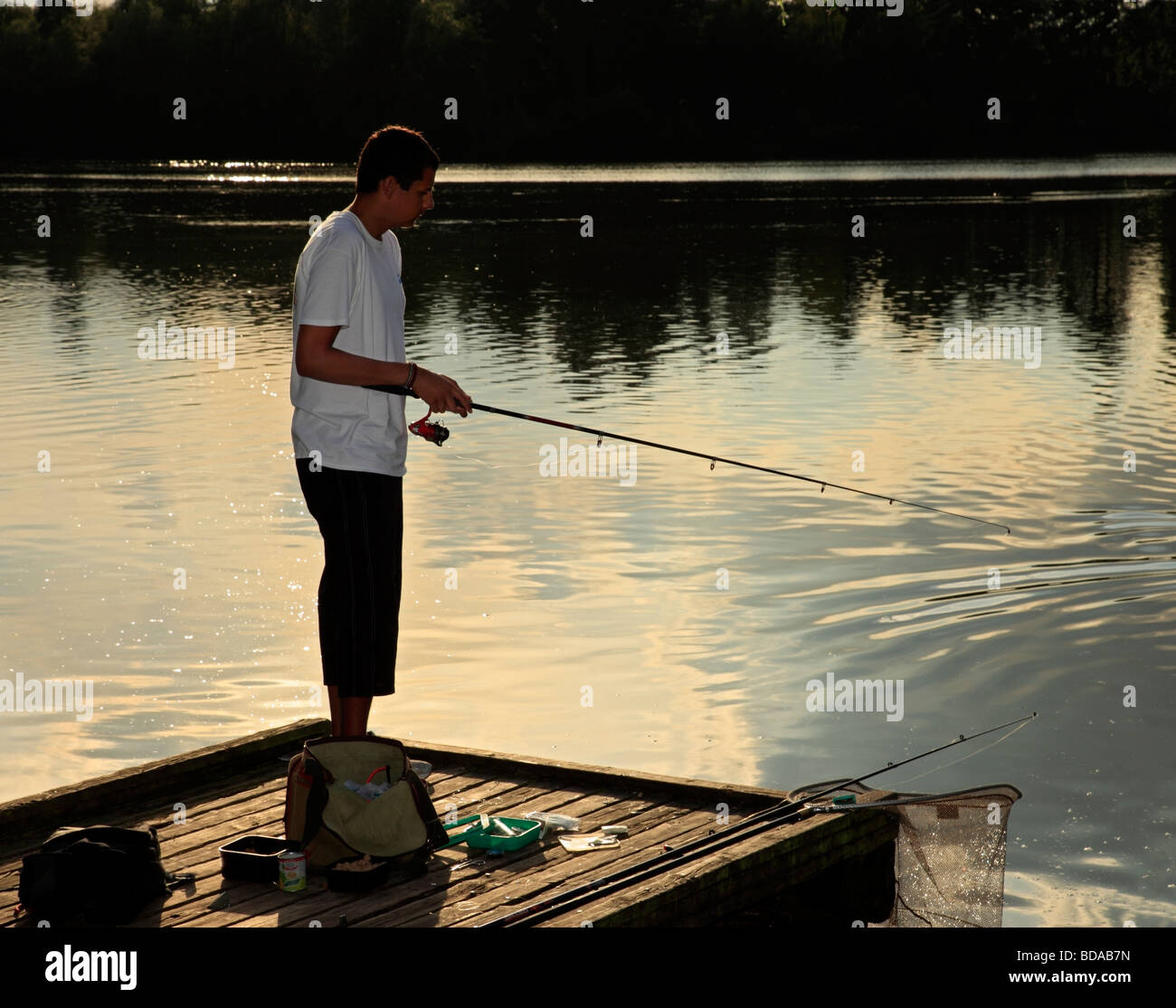 Ragazzo adolescente la pesca al tramonto. Foto Stock