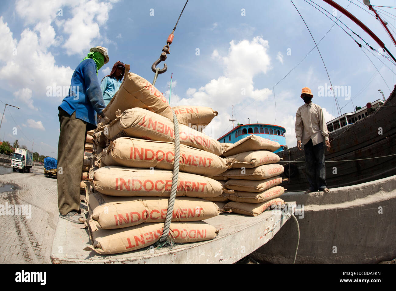 Indonesia Jakarta Java vecchia Batavia Sunda Kelapa lavoratori carico di sacchi di cemento nel calore di metà giornata Foto Stock