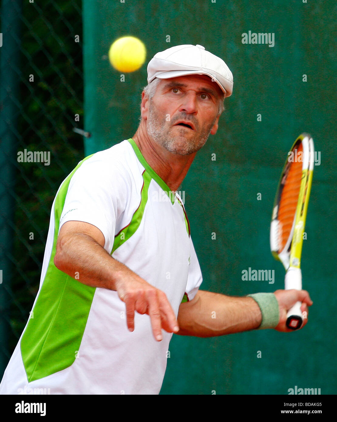 Uomo anziano a giocare a un torneo di tennis Foto Stock