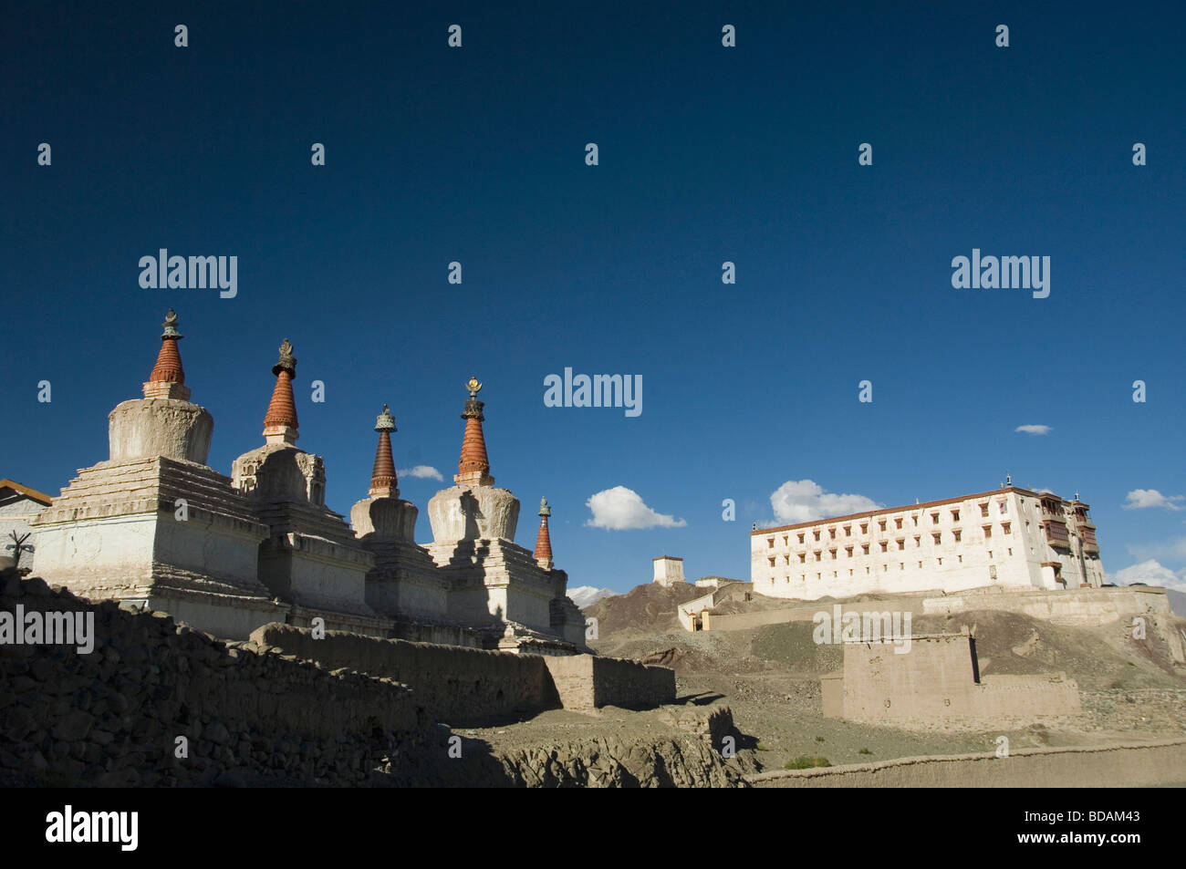 Chortens con un monastero in background, Stok Monastero, Ladakh, Jammu e Kashmir India Foto Stock