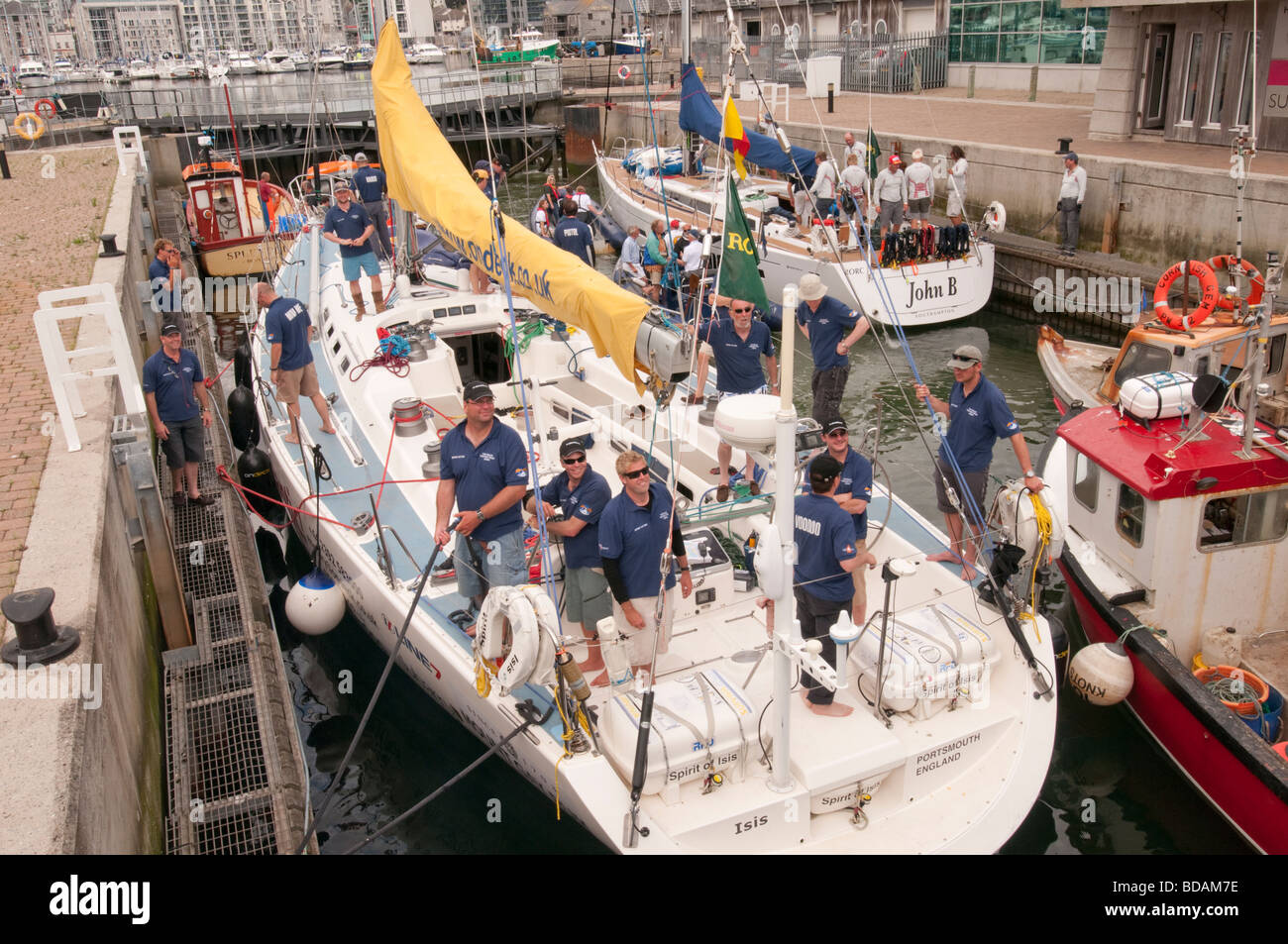 Yacht da Rolex Fastnet race 2009 attendere lungo il lato di barche da pesca nella serratura per immettere Sutton Harbour. Foto Stock