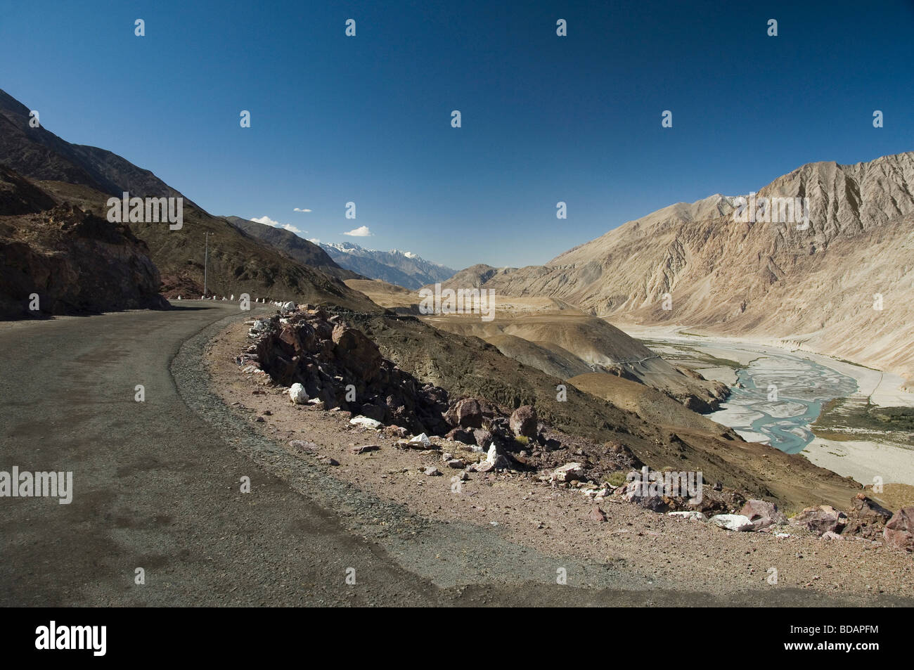 Road passando attraverso una valle lungo un fiume Fiume Shyok, Valle di Nubra, Ladakh, Jammu e Kashmir India Foto Stock