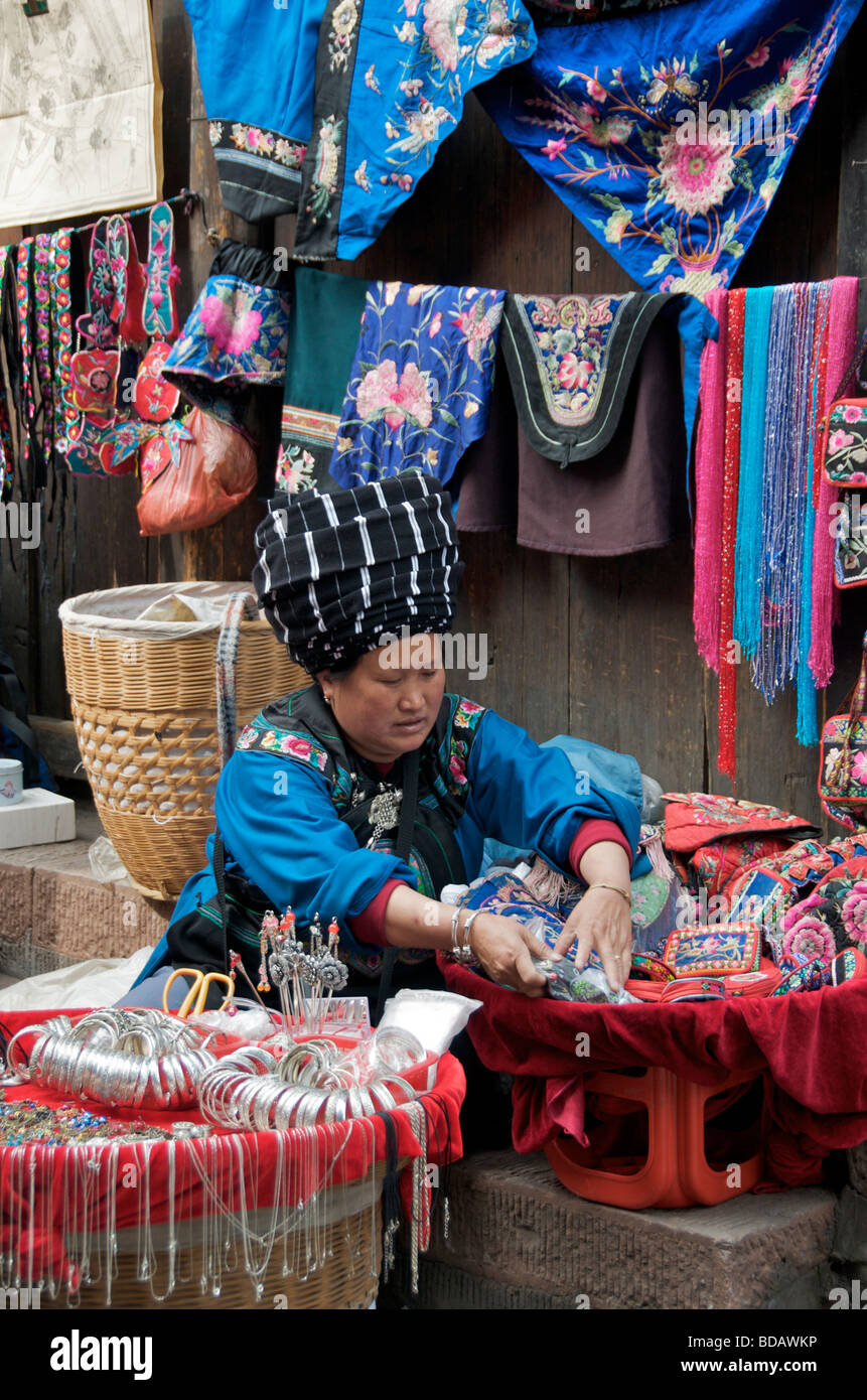 Donna commerciante in emroided vestiti e ciondoli in argento e antica città di Fenghuang Hunan Cina Foto Stock
