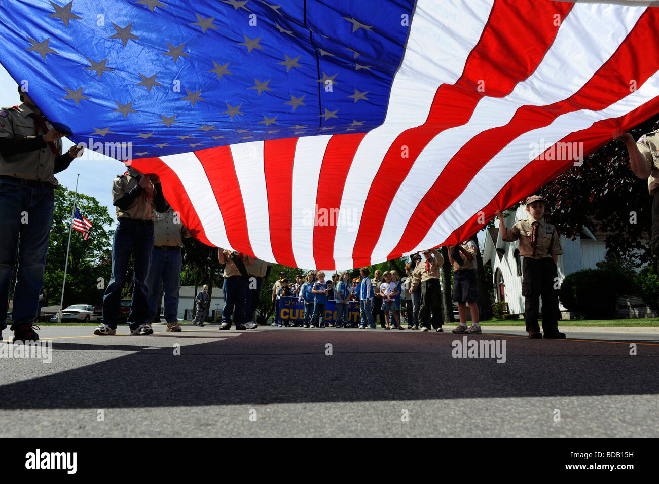 Cub Scout portano grandi bandiera americana nel giorno memoriale della sfilata Foto Stock