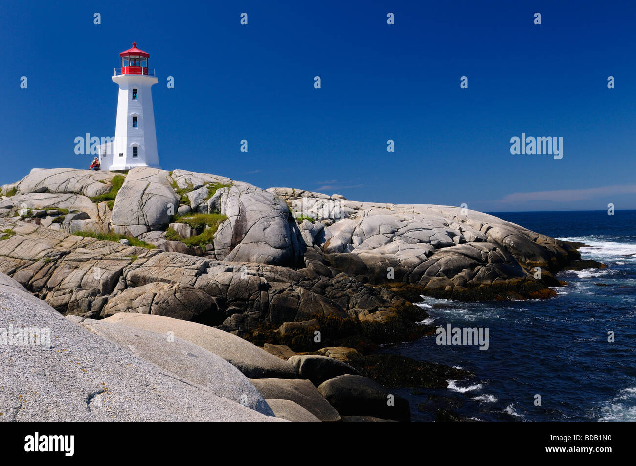 Peggy's Cove Nova Scotia faro sulla liscia di rocce di granito con formare fisarmonica player e surf Foto Stock