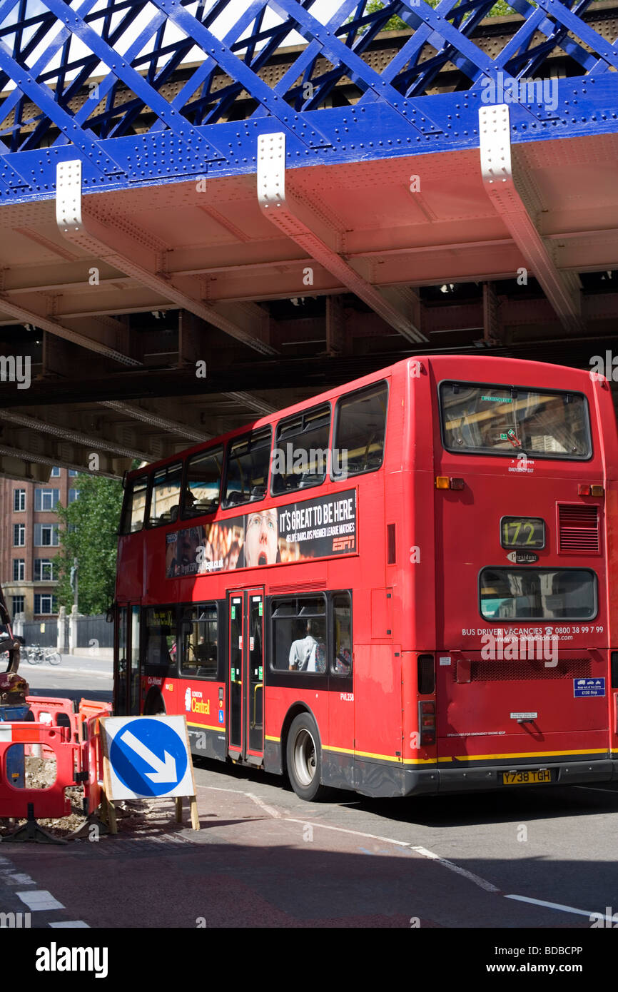 Red London Bus passa sotto il ponte blu, Waterloo, London, England, Regno Unito, Europa Foto Stock