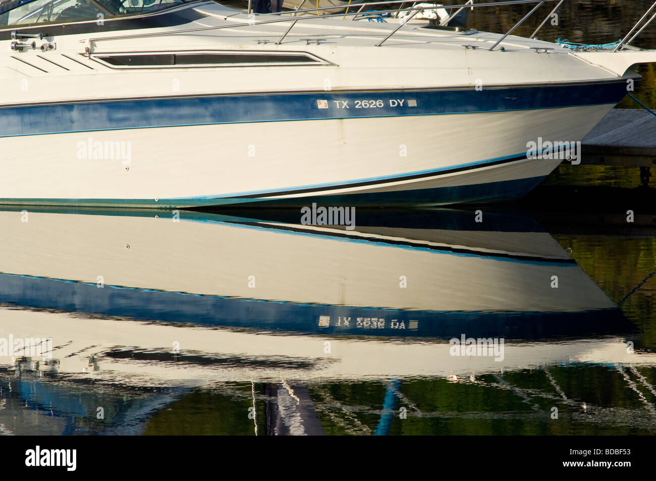 Power Boat che viene riflessa con un'immagine speculare ancora in un lago. Foto Stock