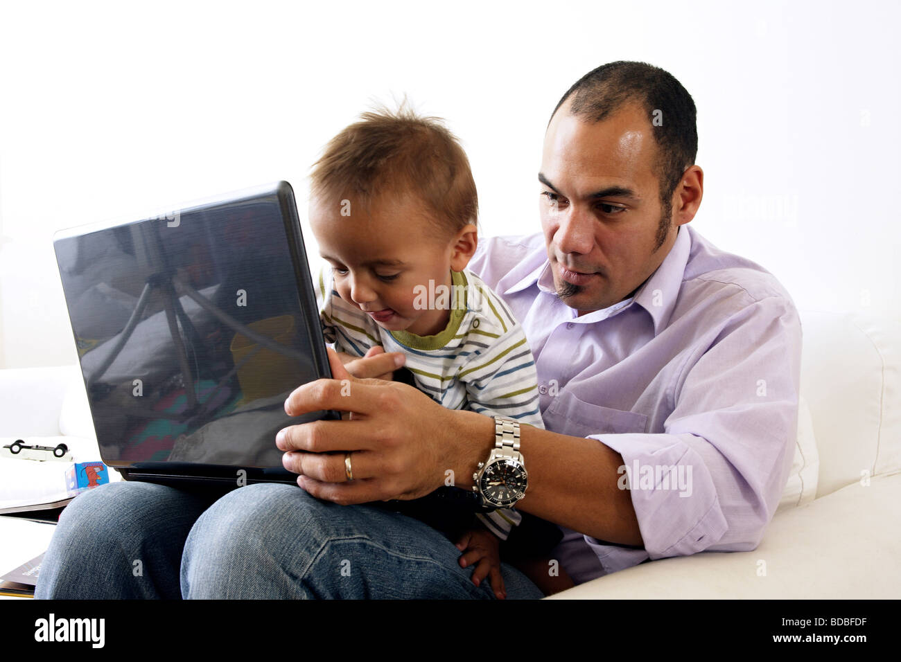 Padre che mostra il suo piccolo figlio di computer portatile Foto Stock