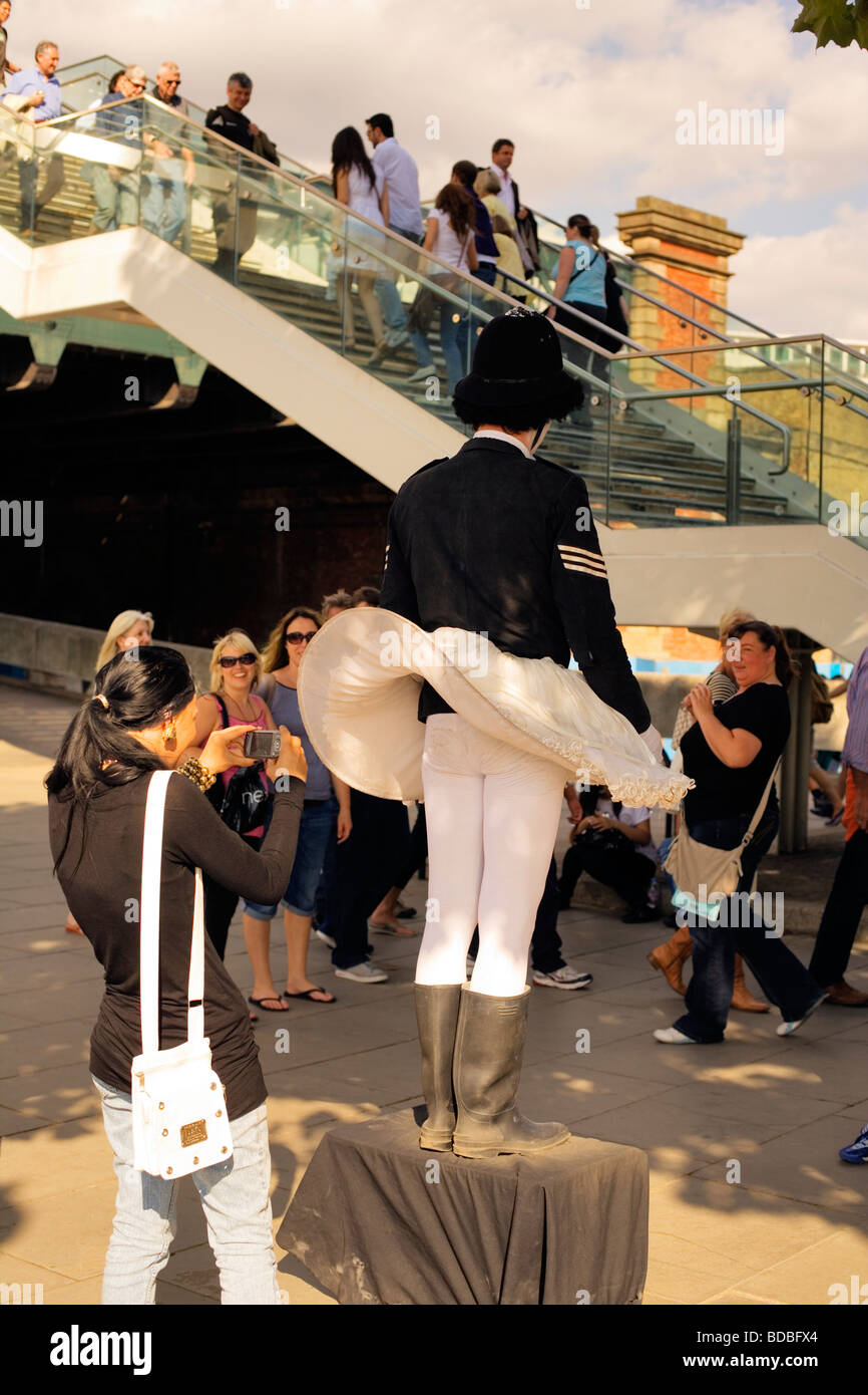 Tourist prende la foto del poliziotto artista di strada - South Bank di Londra, Inghilterra, Regno Unito, Europa Foto Stock