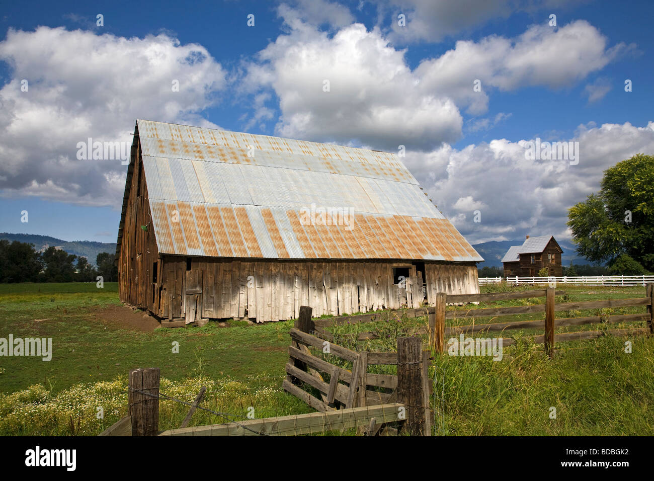 Un vecchio fienile e recinzione di legno su un ranch vicino a metà strada Oregon sulle pendici delle montagne Wallowa in Oregon orientale Foto Stock