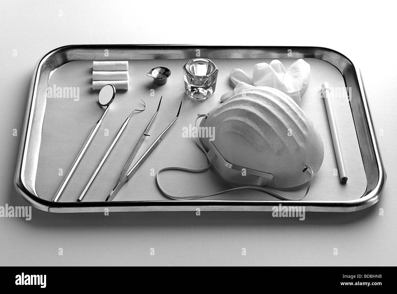 In bianco e nero girato di argento vassoio metallico contenente del dentista strumenti. Foto Stock