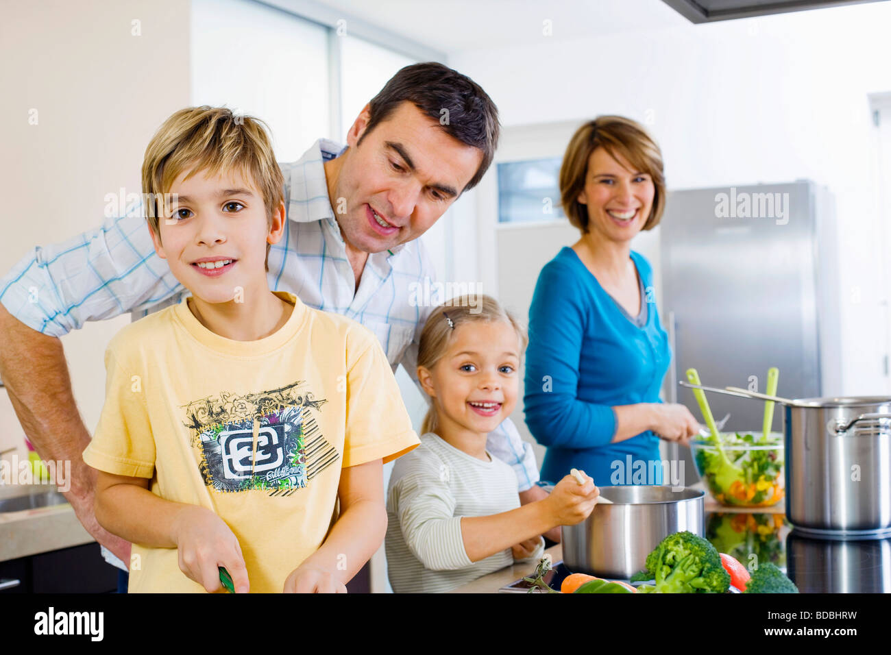 La cottura dei genitori con i loro figli in cucina Foto Stock