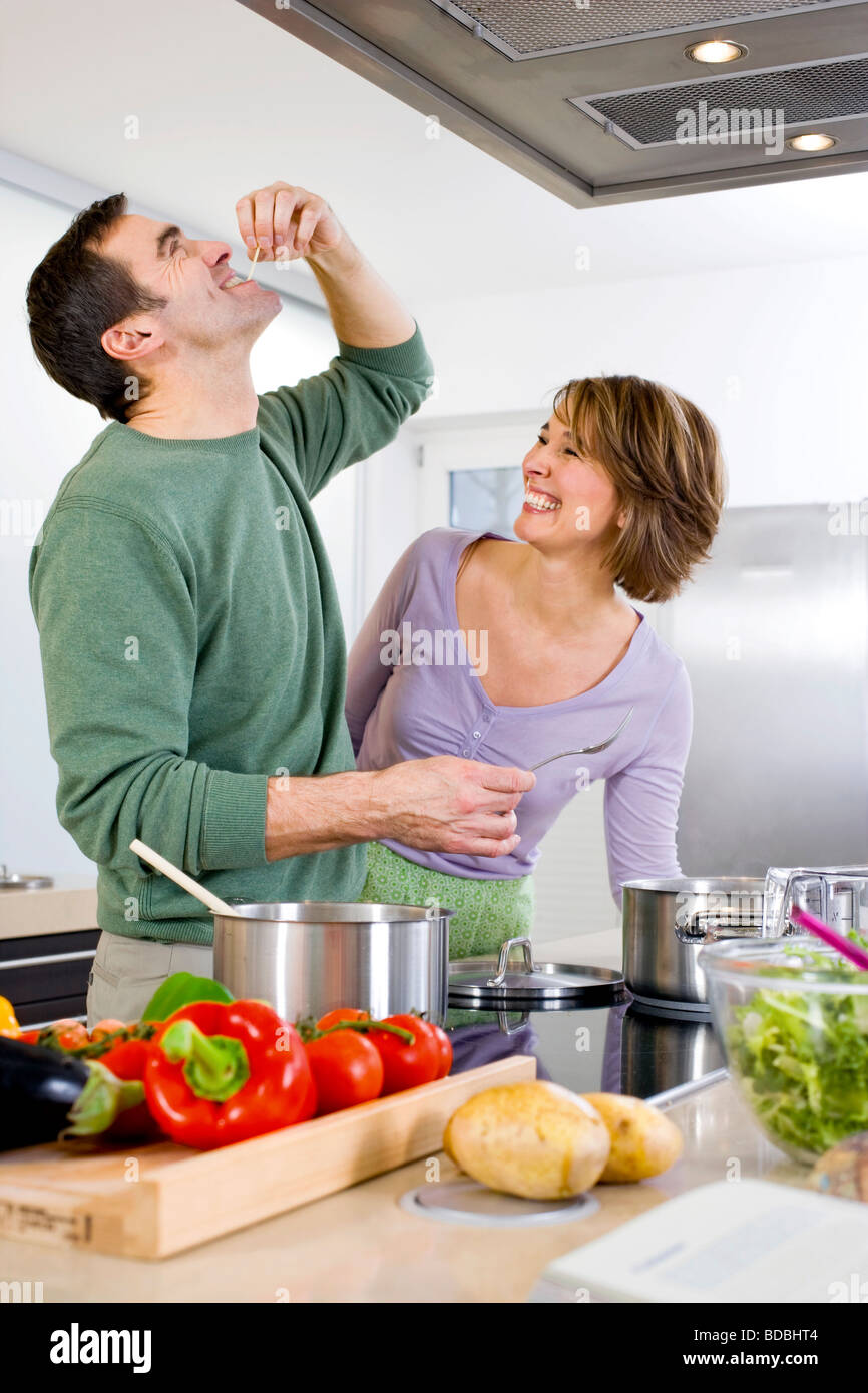 Matura per la cottura in cucina insieme uomo spaghetti di degustazione Foto Stock