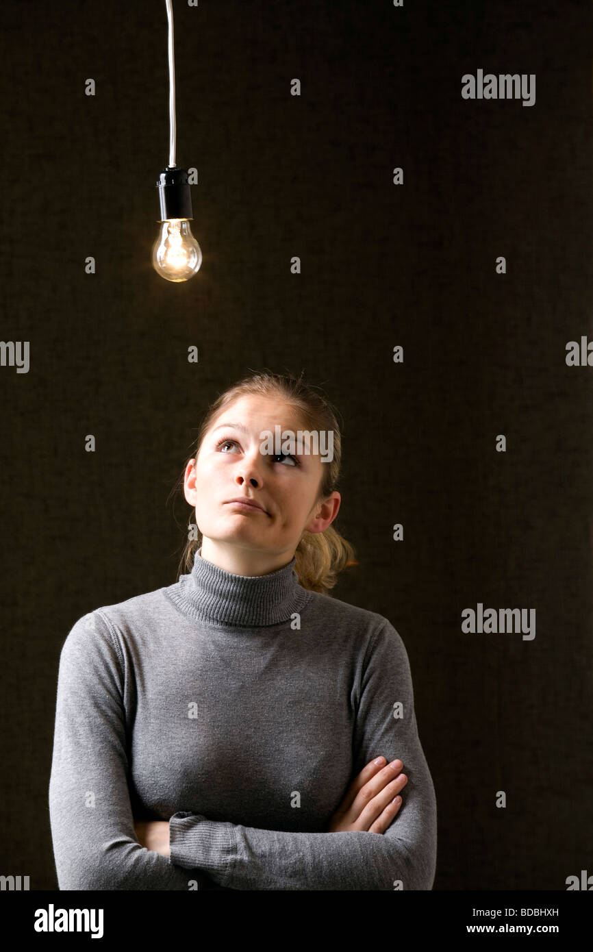 Ritratto di giovane donna sotto la lampadina Foto Stock