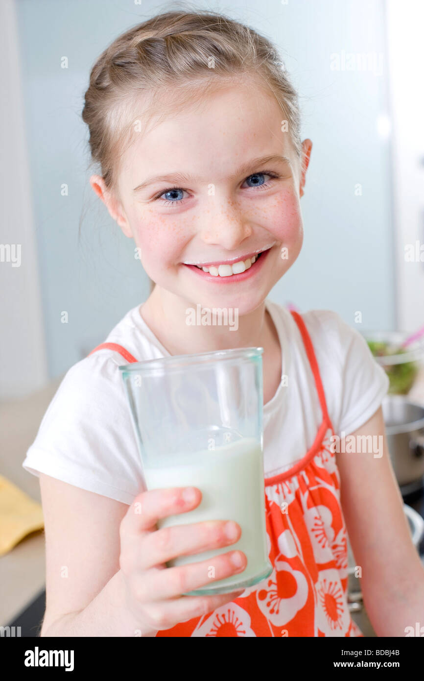 Ritratto di giovane ragazza di bere un bicchiere di latte in cucina Foto Stock