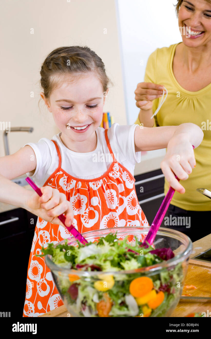 Giovane ragazza in cucina insalata di realizzazione Foto Stock