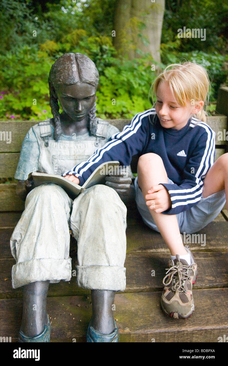 Il piacere della lettura - ragazza con una scultura di una ragazza la lettura di un libro Foto Stock