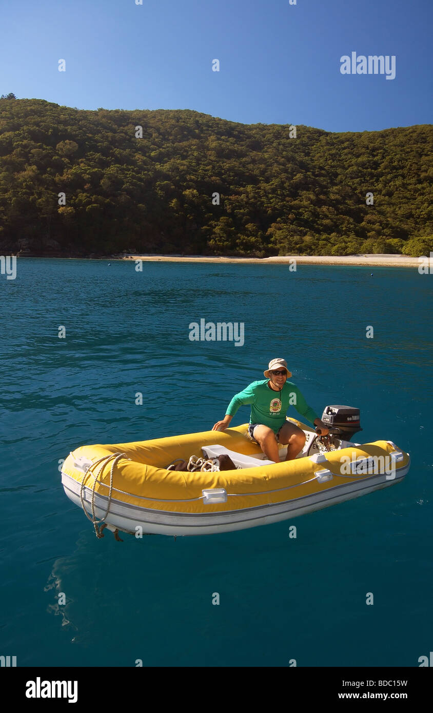 Uomo alla guida di giallo barca gonfiabile in Maureen's Cove, gancio Isola, Whitsunday Islands National Park, Queensland, Australia Foto Stock