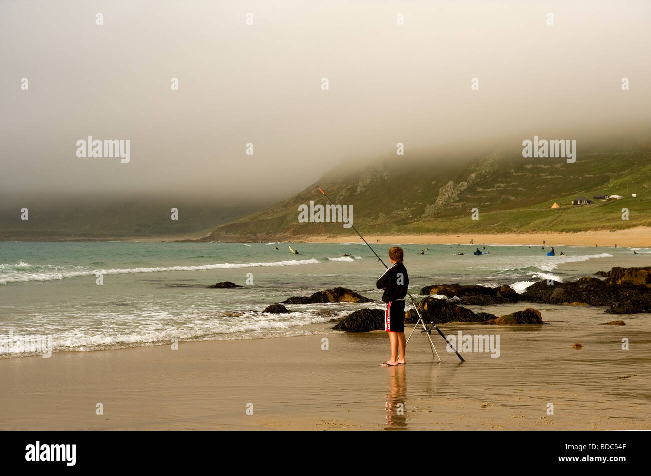 Un pescatore beachfishing in una nebbiosa giornata a Sennen in Cornovaglia. Foto Stock