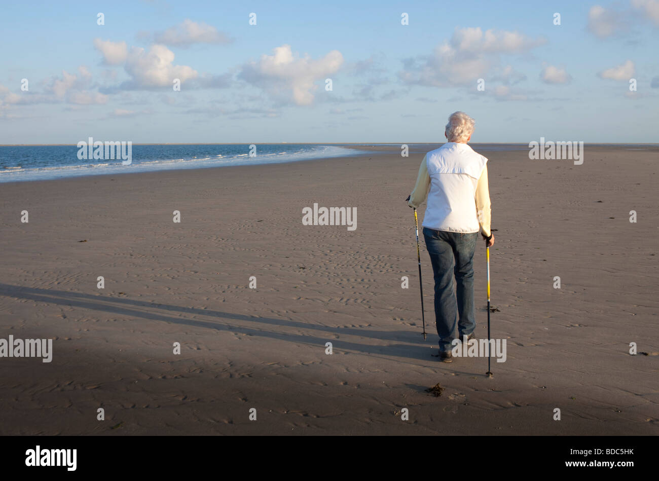 Donna di camminare sulla spiaggia Foto Stock