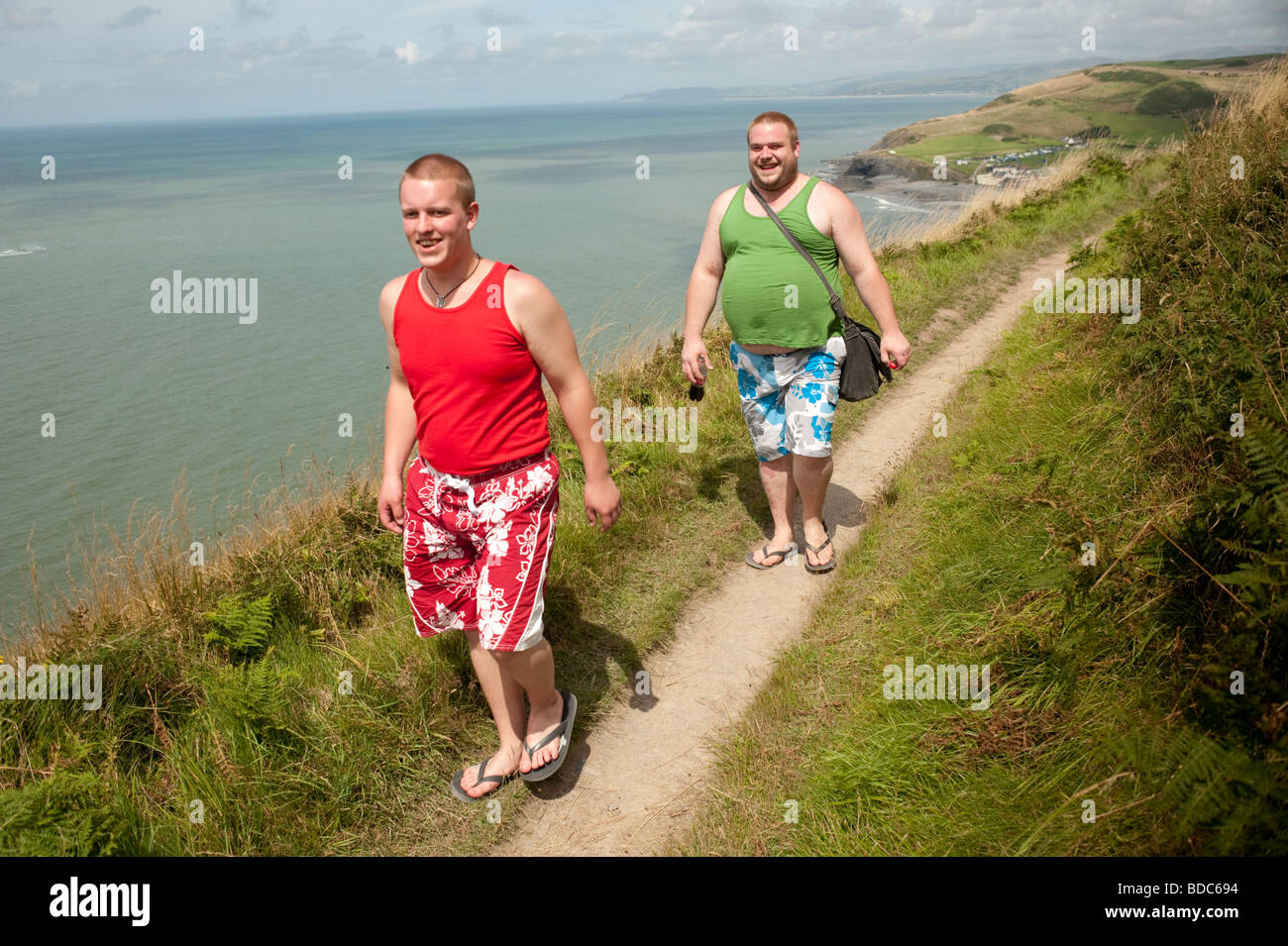 Mattina d'estate, due uomini a piedi lungo il Cardigan Bay ceredigion patrimonio percorso costiero west wales UK Foto Stock