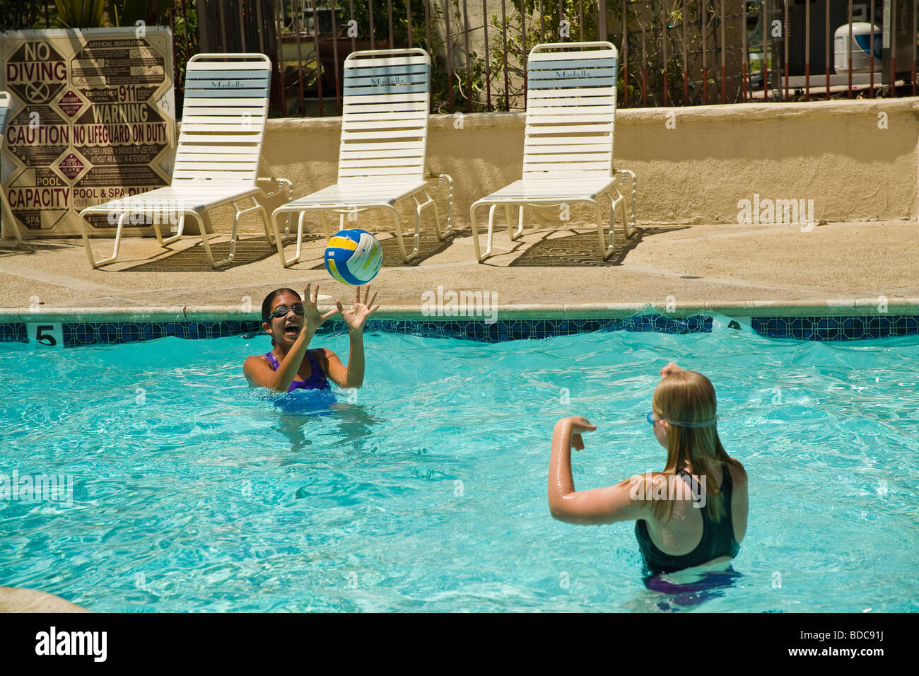 Due teen12-14 anni anni ragazze appendere appendere fuori insieme due junior alta ragazze Ispanico e Caucasico cattura palla in piscina. Signor Foto Stock