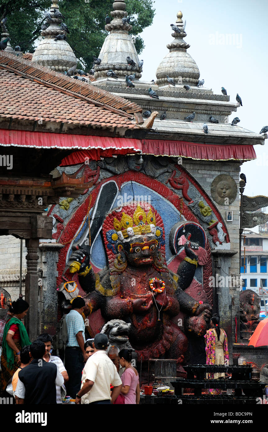 Nero Bhairab statua e fedeli pregano offerta rituale del culto Khal Bhairav Shiva il quadrato di Durbar Kathmandu in Nepal Foto Stock