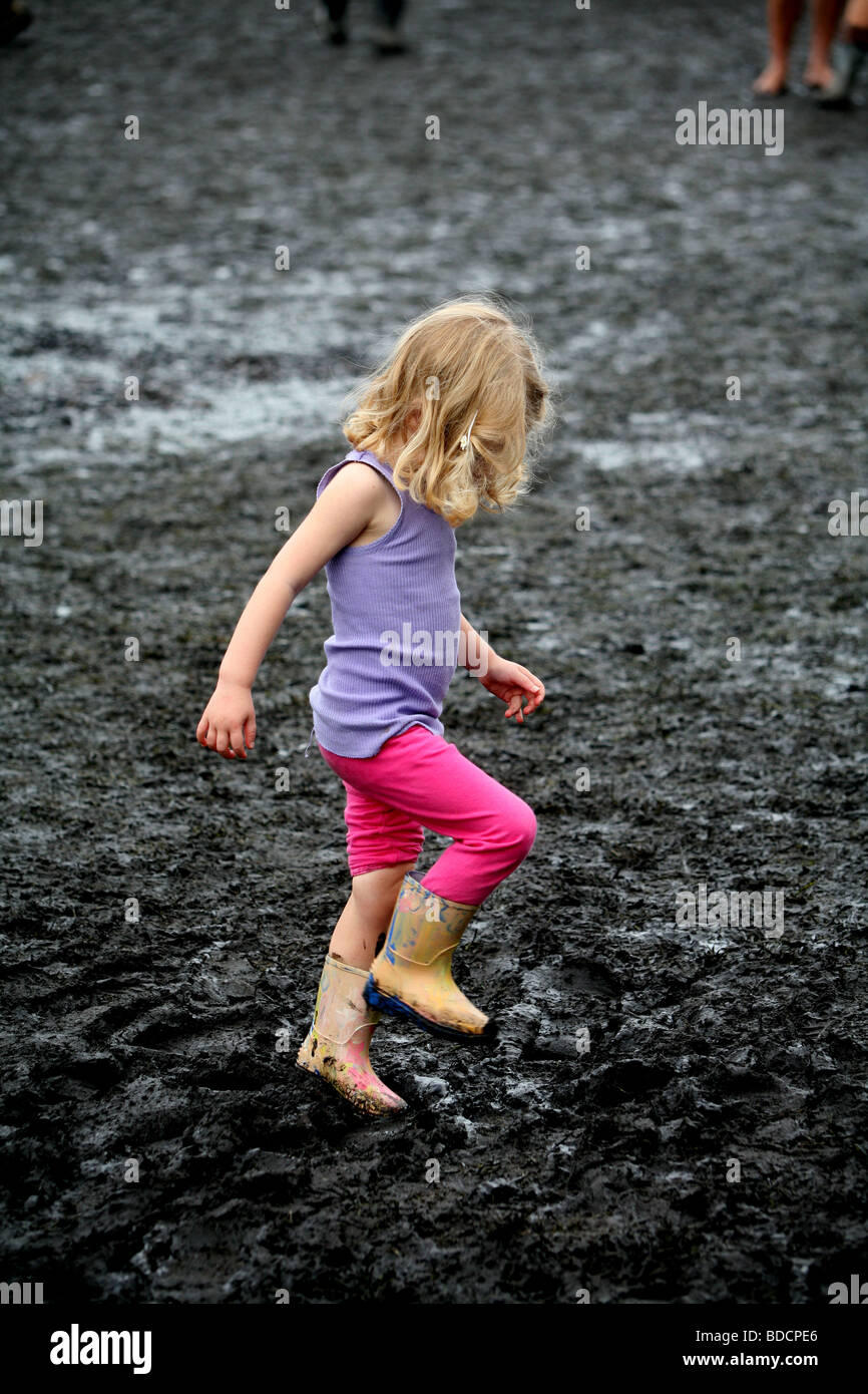 Una giovane ragazza riproduce nel fango. Foto Stock