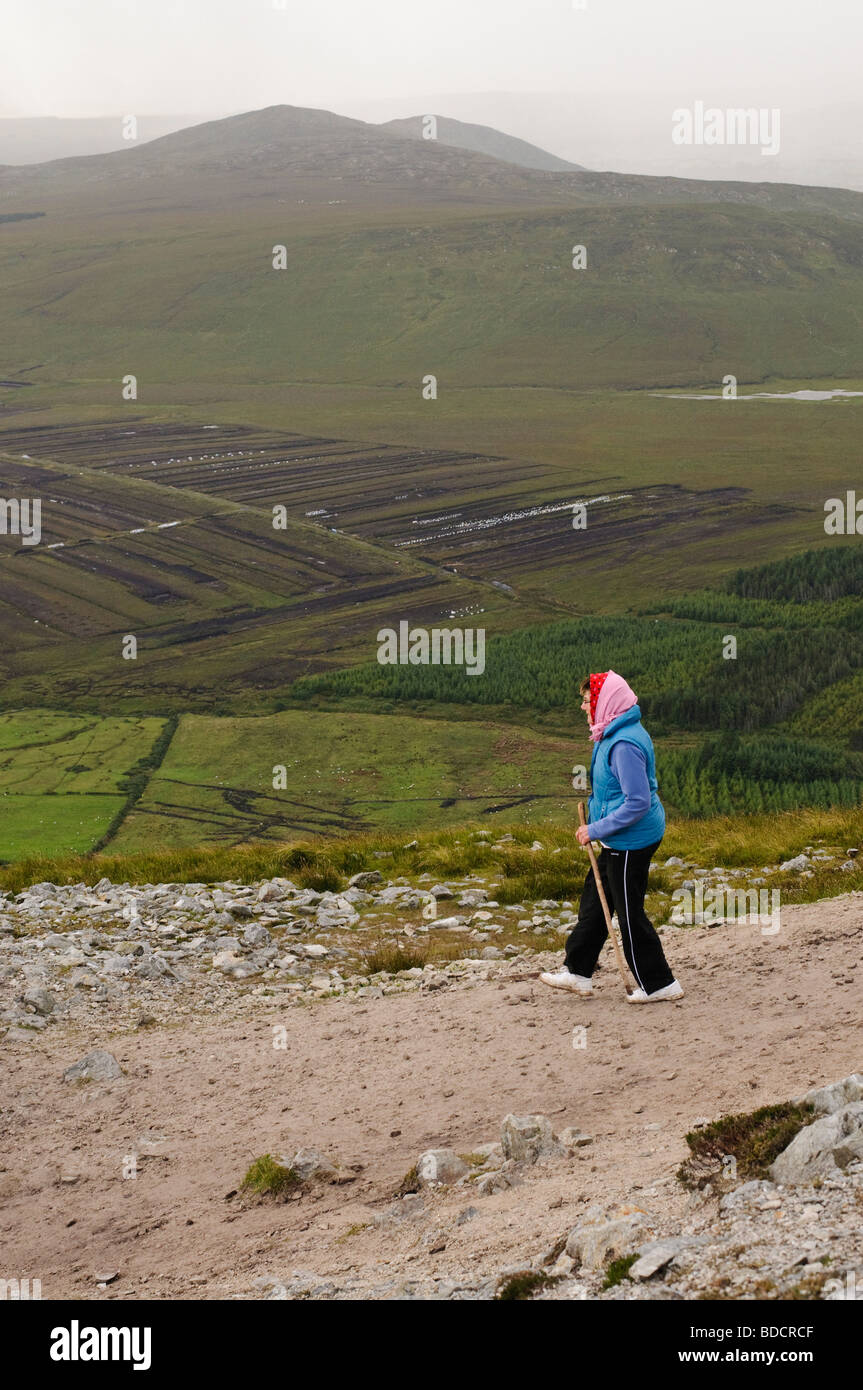 Pellegrino con bastone scendendo dal rocky top sezione di Croagh Patrick su Reek, Domenica, 25 Luglio 2009 Foto Stock