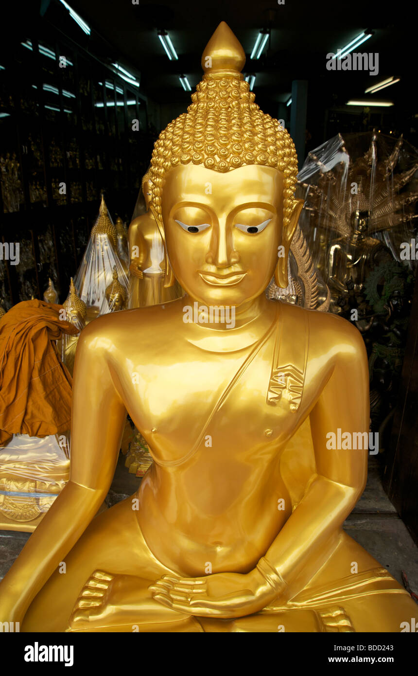 Una statua del Buddha d'oro nuova di zecca si trova in un negozio a Bangkok Thailandia in attesa di essere acquistato per merito rendendo ricchi thailandesi Foto Stock