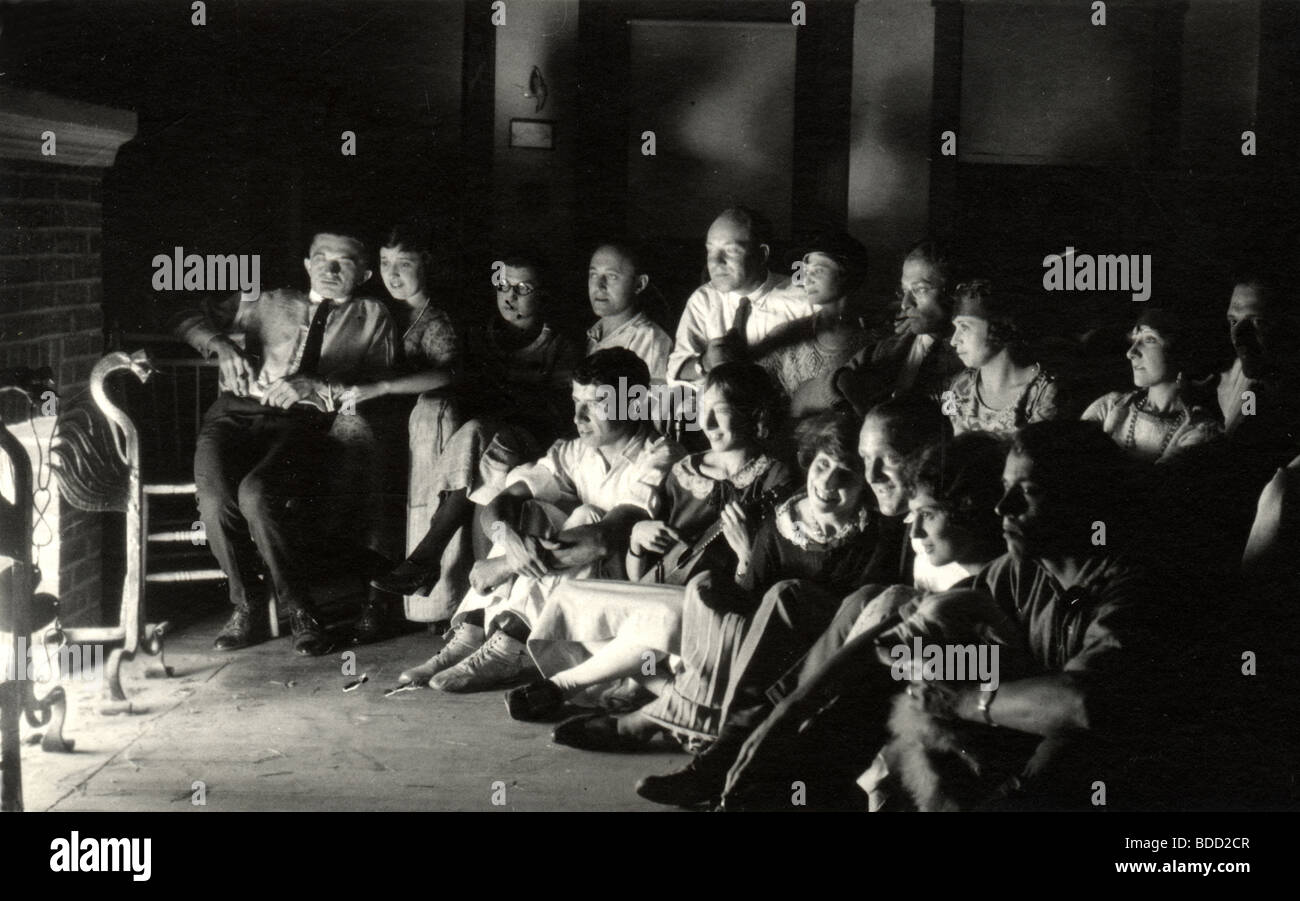 Gruppo seduti davanti al caminetto nel buio Foto Stock