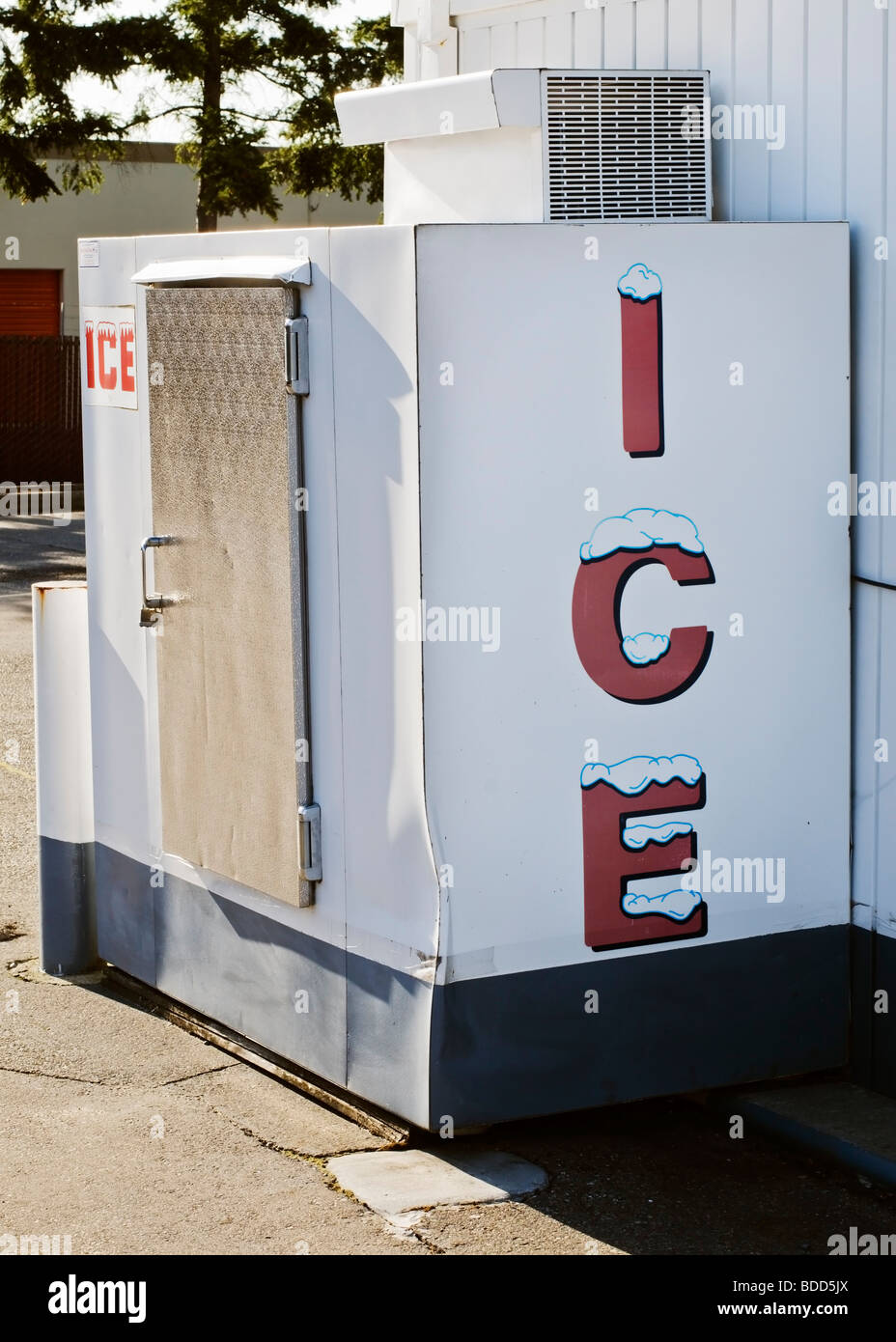 Macchina per il ghiaccio si trova a fianco di un edificio esterno in un parcheggio. Foto Stock