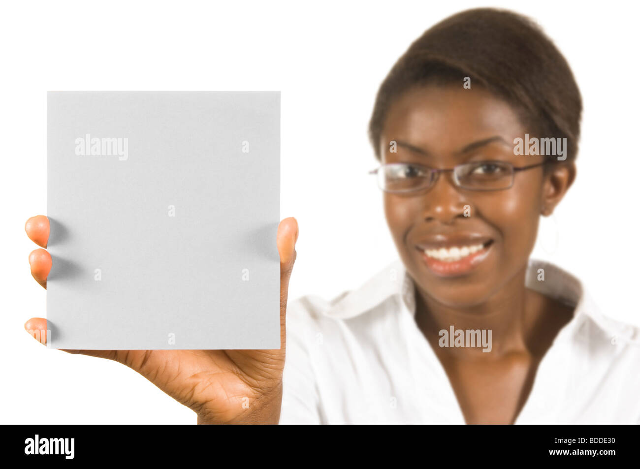 Un felice attraente African business donna con in mano una scheda vuota per il testo o la grafica contro un bianco puro (255) dello sfondo. Foto Stock