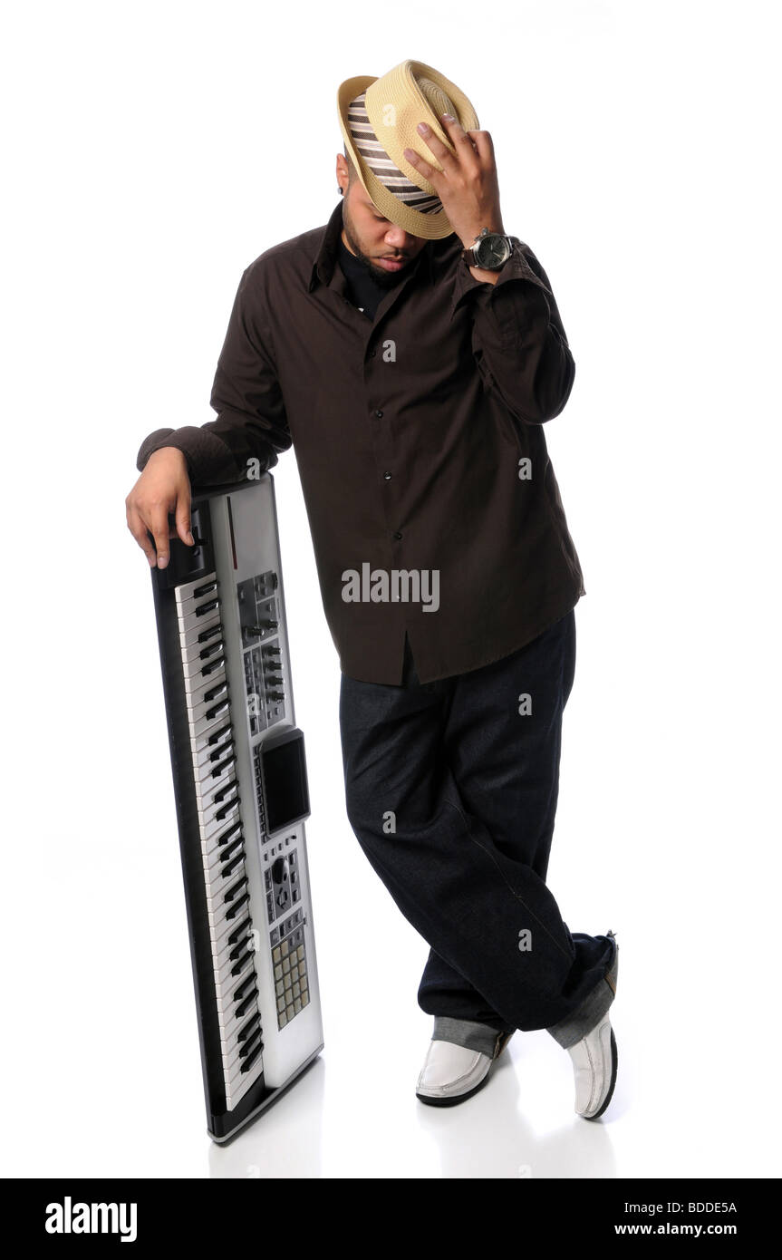 Giovane americano africano che pongono l uomo al fianco di un pianoforte elettrico Foto Stock
