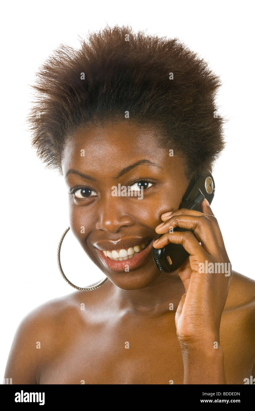 Ritratto in studio di un attraente donna africana su un telefono cellulare felice ed emozionato contro un bianco puro (255) dello sfondo. Foto Stock